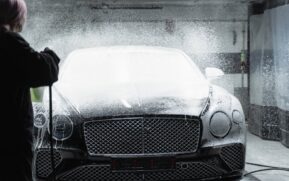 Black luxury car receiving a foamy wash in an indoor car wash service. - Photo by Tima Miroshnichenko on Pexels