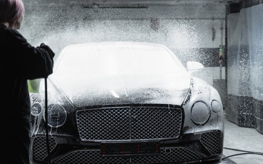 Black luxury car receiving a foamy wash in an indoor car wash service. - Photo by Tima Miroshnichenko on Pexels