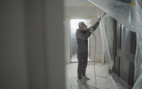 Man in protective gear spray painting a house's interior during renovation work. - Photo by Tima Miroshnichenko on Pexels