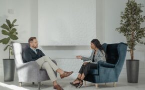 A therapist and patient engaged in conversation in a modern, stylish therapy office. - Photo by Tima Miroshnichenko on Pexels