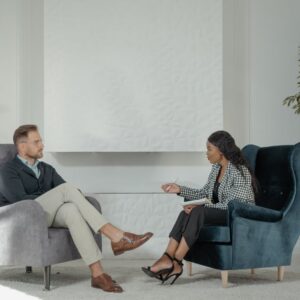 A therapist and patient engaged in conversation in a modern, stylish therapy office. - Photo by Tima Miroshnichenko on Pexels