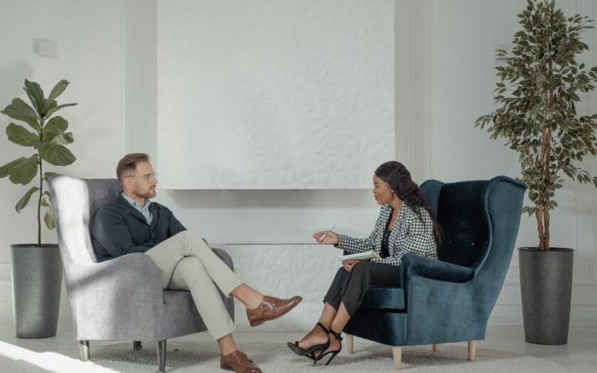 A therapist and patient engaged in conversation in a modern, stylish therapy office. - Photo by Tima Miroshnichenko on Pexels