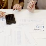 Two professionals analyzing financial documents with a calculator. - Photo by Artem Podrez on Pexels