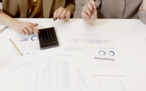 Two professionals analyzing financial documents with a calculator. - Photo by Artem Podrez on Pexels